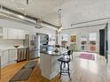 Bright kitchen with stainless steel appliances, center island with breakfast bar, hardwood floors, and access to an outdoor balcony at 1499 Blake St # 3U, Denver, CO 80202