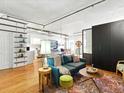 Cozy living room featuring hardwood floors, modern lighting, and a comfortable seating area with an open view to the kitchen at 1499 Blake St # 3U, Denver, CO 80202