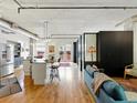 Open-concept living area featuring hardwood floors, modern lighting, and an island with bar stool seating at 1499 Blake St # 3U, Denver, CO 80202