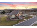Beautiful aerial view of a spacious stucco home with a manicured lawn and mountain backdrop at 16394 W 77Th Ln, Arvada, CO 80007