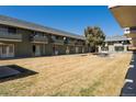 Building exterior featuring second-story balconies, lawn, and mature tree at 9925 W 20Th Ave # 2, Lakewood, CO 80215