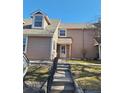 Inviting townhome exterior featuring a covered entry, landscaped yard, and updated siding at 13504 E Asbury Dr, Aurora, CO 80014