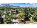 Breathtaking aerial view of the home nestled amongst mature trees with mountain views at 15 Pawnee Dr, Boulder, CO 80303