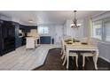 Modern kitchen with stainless steel appliances and white countertops, and a dining area with a dining table at 5360 Monaco St, Commerce City, CO 80022