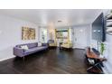 Inviting living room featuring hardwood floors, comfortable seating, and plenty of natural light from the windows at 5360 Monaco St, Commerce City, CO 80022