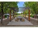 A long, wooden table and benches sit beneath a pergola, providing a shady and inviting outdoor space for gatherings at 8171 E 33Rd Ave, Denver, CO 80238