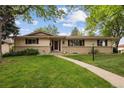 Charming single-story home with manicured lawn, mature trees, and welcoming front porch at 3298 S Krameria St, Denver, CO 80222