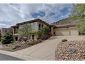 Charming home with a three-car garage, landscaped front yard, and stucco and stone accents at 5951 Rain Dance Trl, Littleton, CO 80125