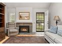 Warm living room featuring a fireplace, tile hearth, hardwood floors, and a cozy sitting area at 7761 S Curtice Dr # C, Littleton, CO 80120