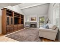 Spacious living room with a large entertainment center, vaulted ceiling, fireplace, and hardwood floors at 7761 S Curtice Dr # C, Littleton, CO 80120