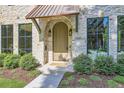 Close-up of a stone house's front door with a copper awning and sidelight windows at 2365 S Clayton St, Denver, CO 80210