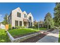 Charming two-story stone home with manicured lawn and landscaped pathway at 2365 S Clayton St, Denver, CO 80210
