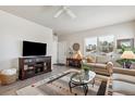 Comfortable living room featuring a TV, ceiling fan, and bright windows at 763 Sage Forest Ln, Monument, CO 80132