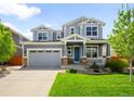 Inviting two-story home with a blue front door, attractive siding, a two-car garage, and a beautifully landscaped front yard at 10057 Des Moines St, Parker, CO 80134