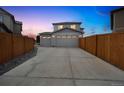A long driveway at dusk, leading to a well-lit two car garage at 11677 Park South Ln, Parker, CO 80138