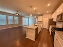 Open concept living area featuring a kitchen island, hardwood floors, and plenty of natural light at 15861 E Otero Ave, Centennial, CO 80112