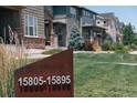 Street view showcasing community homes, green lawns, and clear signage with property address numbers at 15861 E Otero Ave, Centennial, CO 80112
