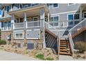 Townhouse exterior featuring stone accents and private wooden staircase at 9351 Amison Cir # 104, Parker, CO 80134