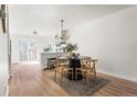 Open concept dining area featuring a round table, modern chandelier, and an adjacent kitchen at 7050 W Cedar Ave # 108, Lakewood, CO 80226