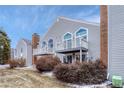 Two-story townhome featuring a chimney and upper level decks with white railing at 3337 S Monaco Pkwy # C, Denver, CO 80222