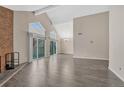 Spacious living room with wood floors, high ceilings, brick fireplace, and balcony access at 3337 S Monaco Pkwy # C, Denver, CO 80222