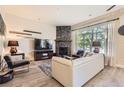 Cozy living room with a stone fireplace, a large window with natural light, and modern furnishings and decor at 5401 S Park Terrace Ave # 109A, Greenwood Village, CO 80111
