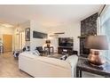Inviting living room featuring a stone fireplace, contemporary furniture, and wood-look floors with ample natural light at 5401 S Park Terrace Ave # 109A, Greenwood Village, CO 80111