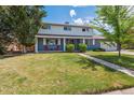 Charming two-story home featuring a lush green lawn and a welcoming front porch at 6726 S Franklin St, Centennial, CO 80122