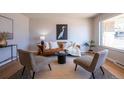 Stylish living room features a comfortable leather sofa, accent chairs, and a bright window at 1849 S Van Gordon Ct, Lakewood, CO 80228