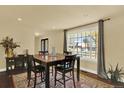 A dining room with natural light and a decorative rug underneath a wood table with seating for four at 7631 Oak St, Arvada, CO 80005