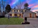 Charming two-story home with a brick facade, well-manicured lawn, and a three-car garage on a nicely landscaped lot at 7631 Oak St, Arvada, CO 80005