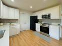 Modern kitchen features white cabinets, stainless steel appliances, and wood-look flooring at 2118 S Mobile Way, Aurora, CO 80013