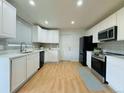Bright kitchen features white cabinets, stainless steel appliances and wood-look flooring at 2118 S Mobile Way, Aurora, CO 80013