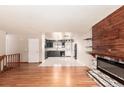 Open living room boasts hardwood floors, modern fireplace, and access to the spacious kitchen at 6343 Depew St, Arvada, CO 80003