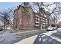Brick apartment building with multiple balconies on a street with parked cars at 1270 N Marion St # 505, Denver, CO 80218