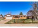 Exterior of a single-story home with a well-manicured lawn and a charming wooden fence at 9231 W Louisiana Ave, Lakewood, CO 80232