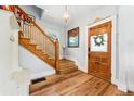 Elegant foyer featuring hardwood floors, a wooden staircase, and a decorative front door, creating a warm welcome at 621 S Sherman St, Denver, CO 80209