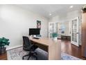 Spacious office with a modern desk setup, hardwood floors, and glass doors leading to the outside at 3410 Uinta St, Denver, CO 80238