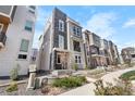 Modern townhome with gray siding, stone accents, and landscaped front yard at 11918 Mountview Ln, Broomfield, CO 80021