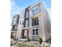 Modern townhome with stone accents, a small balcony, and professionally landscaped front yard at 11918 Mountview Ln, Broomfield, CO 80021