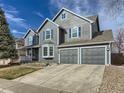 Beautiful two-story home with a well-maintained lawn, showcasing its spacious two-car garage and tasteful gray siding at 8862 Chestnut Hill Ln, Highlands Ranch, CO 80130