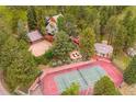 Aerial view showcasing the beautiful property with a tennis court, backyard fire pit and detached garage at 33208 Alta Vista Dr, Evergreen, CO 80439