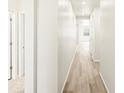 Inviting hallway with light wood flooring, freshly painted walls, and recessed lighting creates a modern, welcoming path at 6050 Hourglass Dr, Brighton, CO 80601