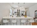 Bright kitchen features stainless appliances, white cabinets, and large center island with bar seating at 3444 Lawrence St, Denver, CO 80205