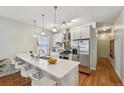 Bright kitchen features stainless appliances, white cabinets, and large center island with bar seating at 3444 Lawrence St, Denver, CO 80205