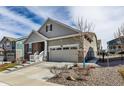Inviting home with two-car garage, manicured lawn, stone and siding details and concrete stairs to front entry at 8230 S White Crow St, Aurora, CO 80016