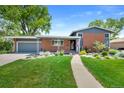 Inviting front exterior with well-manicured lawn, walkway, and attached garage on a sunny day at 6040 Taft Ct, Arvada, CO 80004