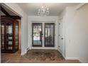 Elegant foyer with wood floors, a chandelier, and shuttered doors leading to the outside at 5000 S Chester St, Greenwood Village, CO 80111