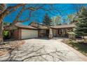 Ranch-style home boasts brick accents, attached garage, and professionally landscaped front yard at 5000 S Chester St, Greenwood Village, CO 80111