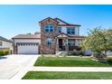 Beautiful two-story home with a stone facade, a two-car garage, a manicured lawn, and mature landscaping at 12035 Fontberry St, Parker, CO 80134